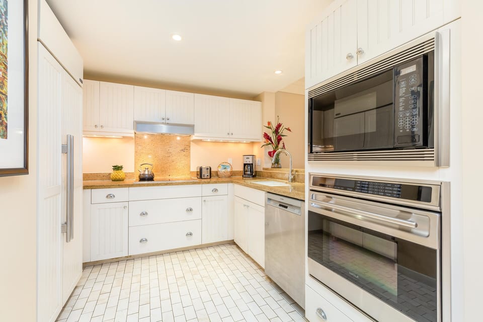 Prepare fresh island dishes in the spacious kitchen, featuring stainless steel appliances and plenty of counter space.