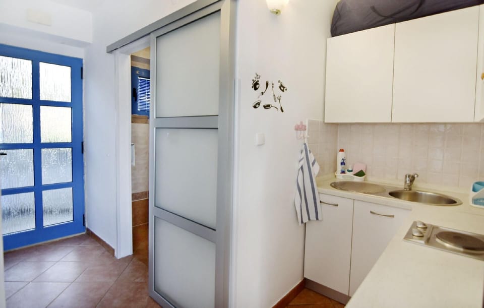 The kitchen with the corridor leading to the bathroom and the exit.