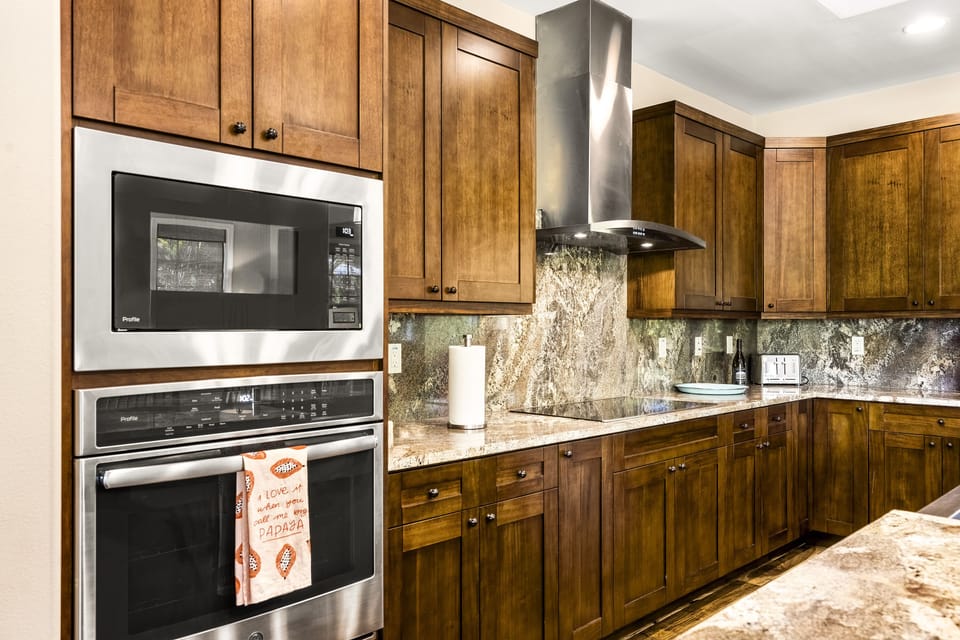 Angled photo of the kitchen, displaying the oven, microwave, and range built into the counter.