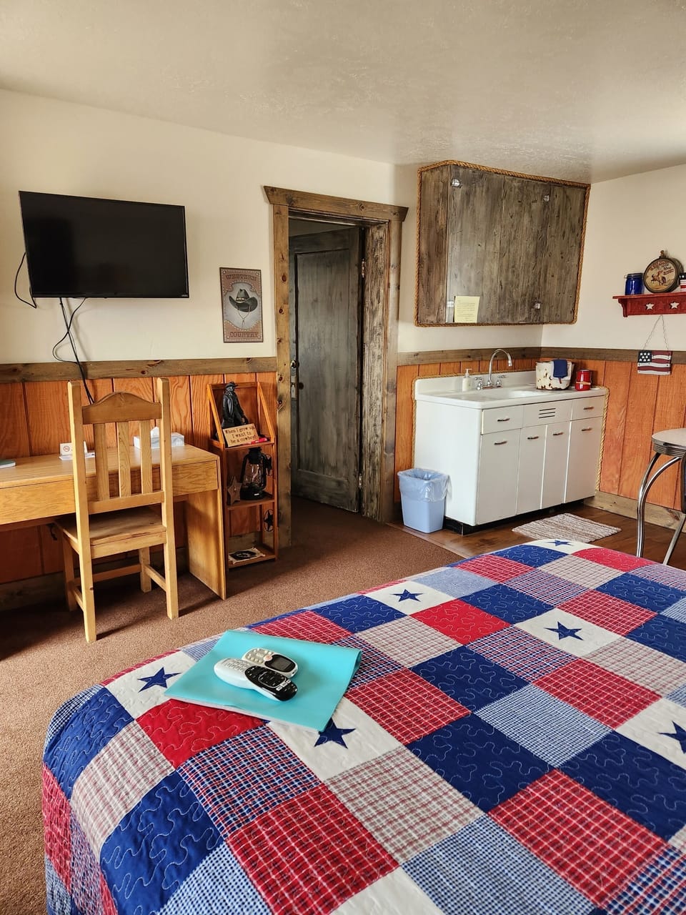 American Cowboy Suite (bed with sitting area and tv as well as kitchenette to right)
