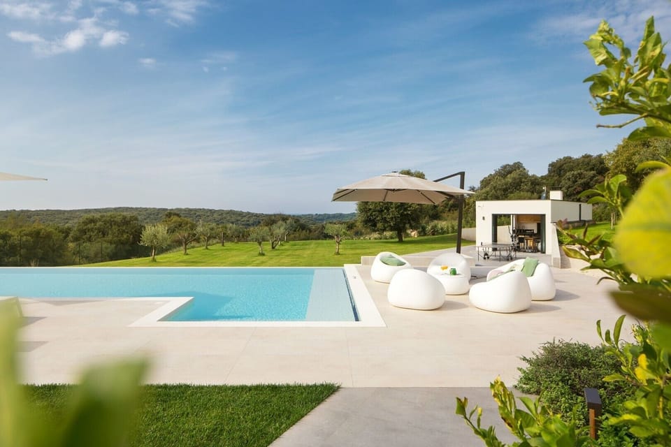 Lounge sofas and parasol on the outdoor terrace next to the private pool in the luxury Croatia villa for vacation