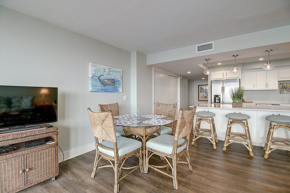 Relax in your bright, open dining area with coastal-style wicker seating and a modern kitchen perfect for preparing memorable meals together.