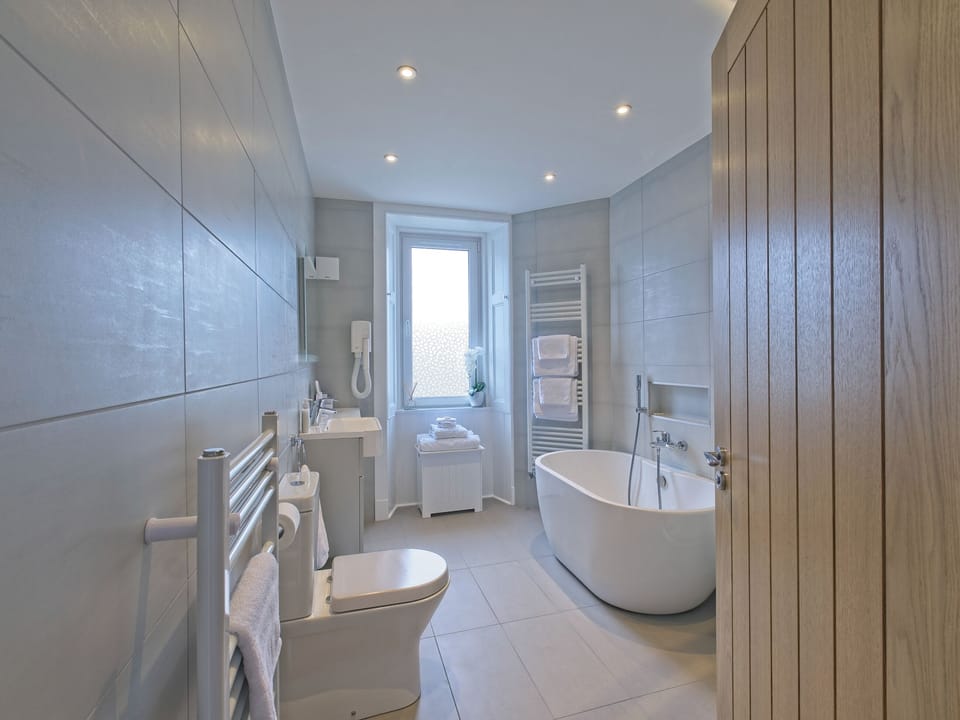 Bathroom with separate shower unit, toilet and basin with storage. In addition, two heated towel rails, heated mirror and a heated tiled floor. | Lower Canterbury House, Gattonside, near Melrose