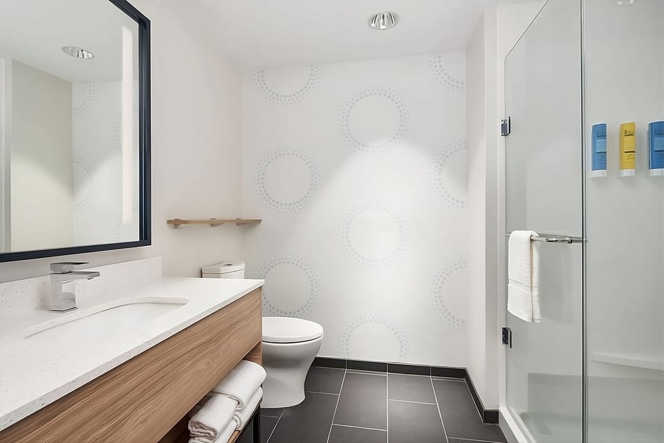 Refresh effortlessly in a spotless bath with bright vanity lighting.