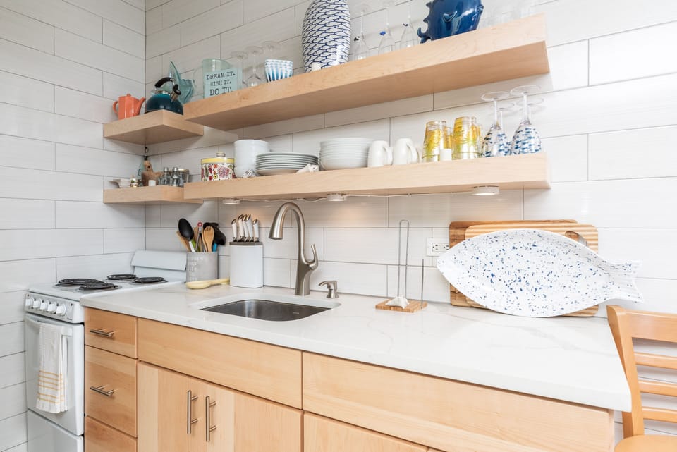 Floating shelves in nicely renovated kitchen.