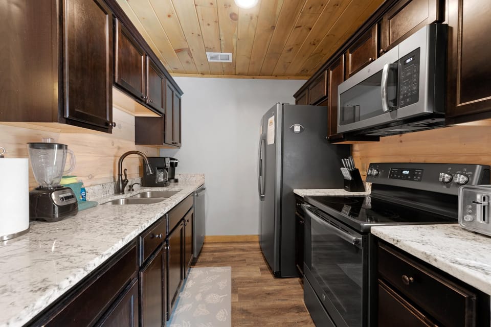 The kitchen is fully stocked with dishes, pots, pans, and stainless steel appliances. Both a drip coffee maker and Keurig are at your service!
