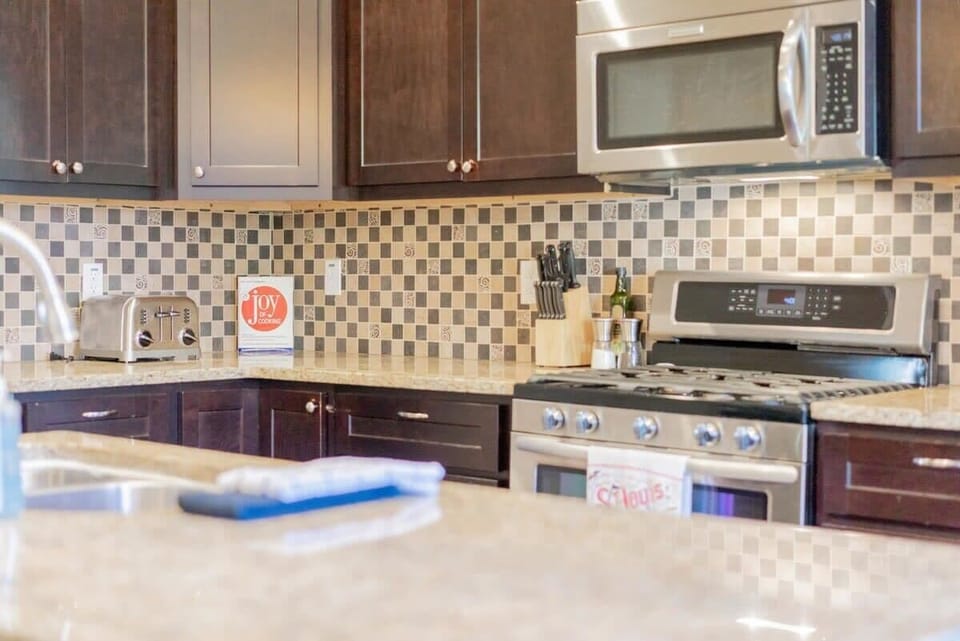 The kitchen features sleek granite benchtops and stainless steel appliances