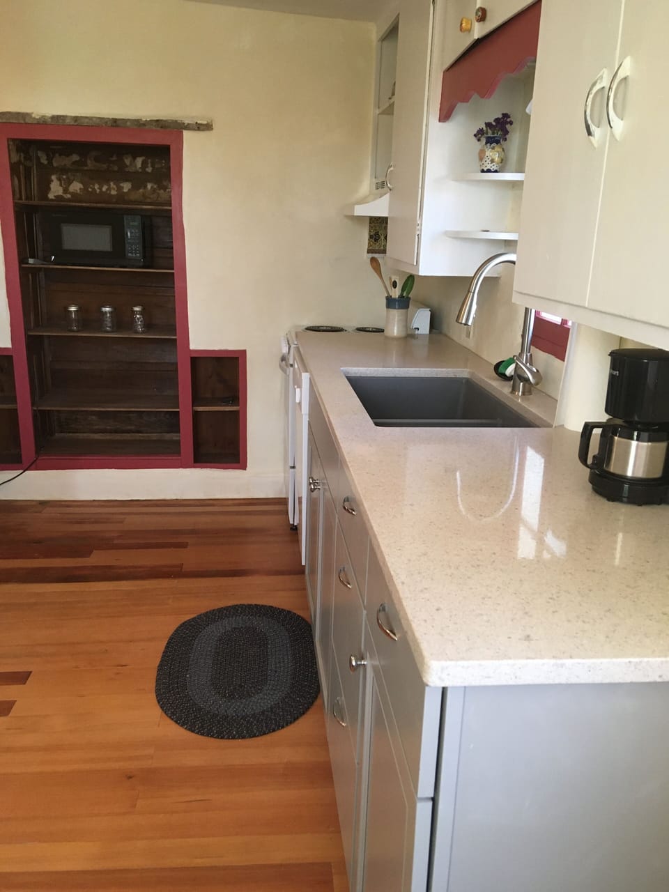 A modern kitchen (including dishwasher) also has a pantry hid in the adobe. wall