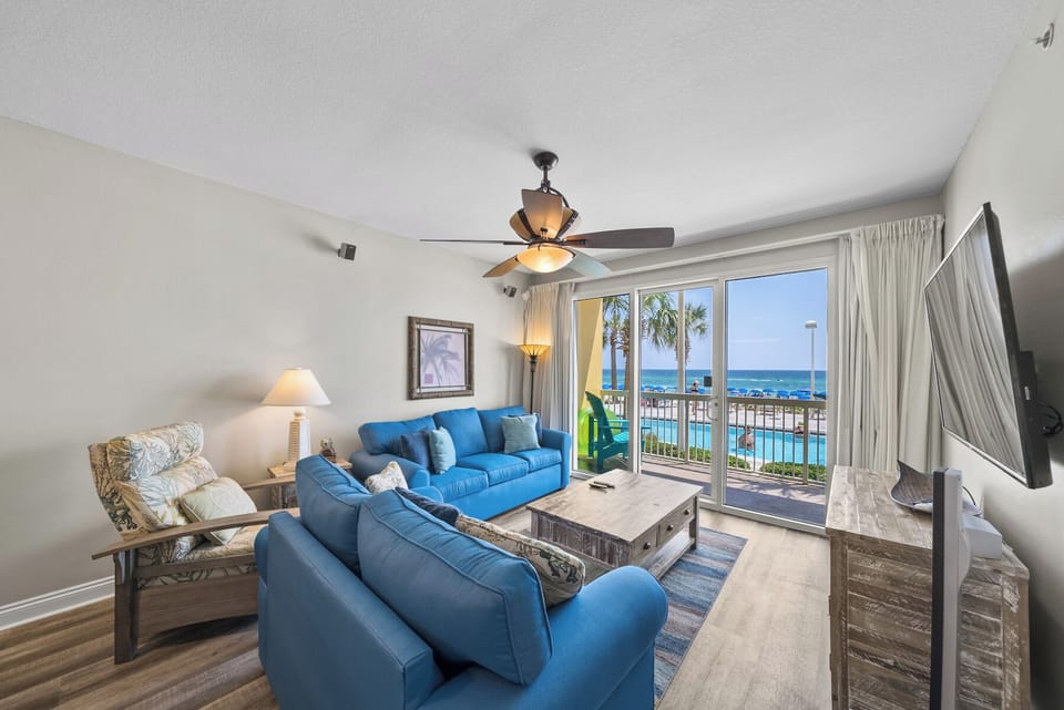 Relax in your coastal living room with ocean views and vibrant blue furnishings that mirror the sea beyond your balcony.
