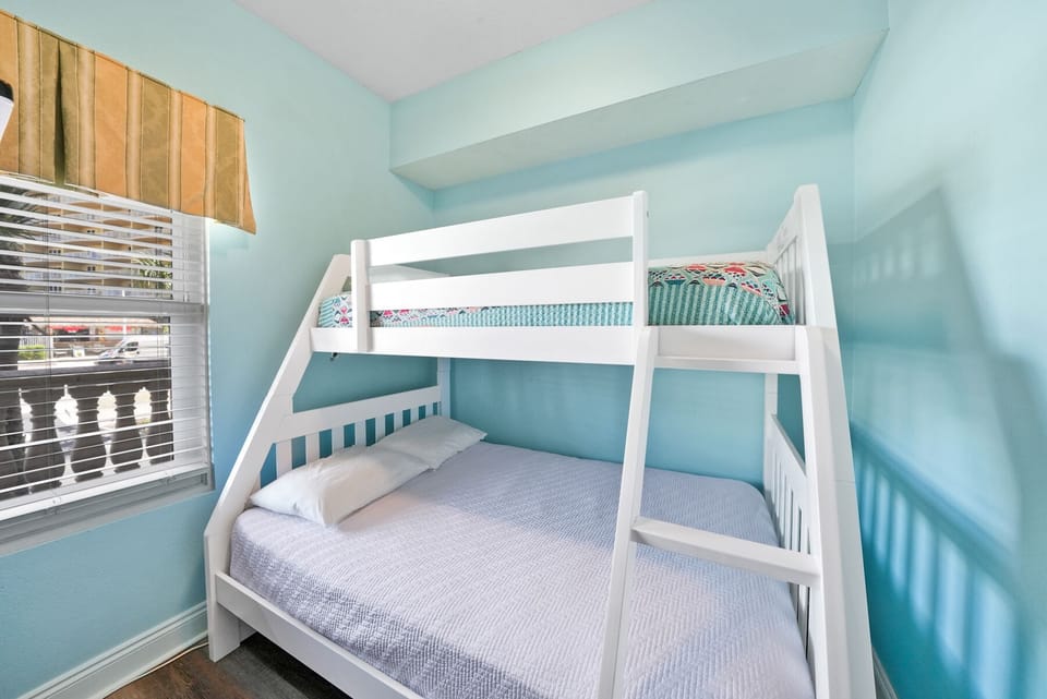 Your kids will love this cheerful bunk room with soft aqua walls and comfy bedding for restful nights.