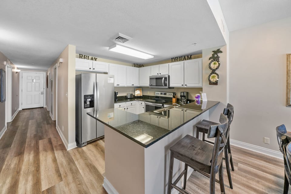 Your modern kitchen features granite counters, stainless appliances, and a breakfast bar perfect for morning coffee or meal prep.