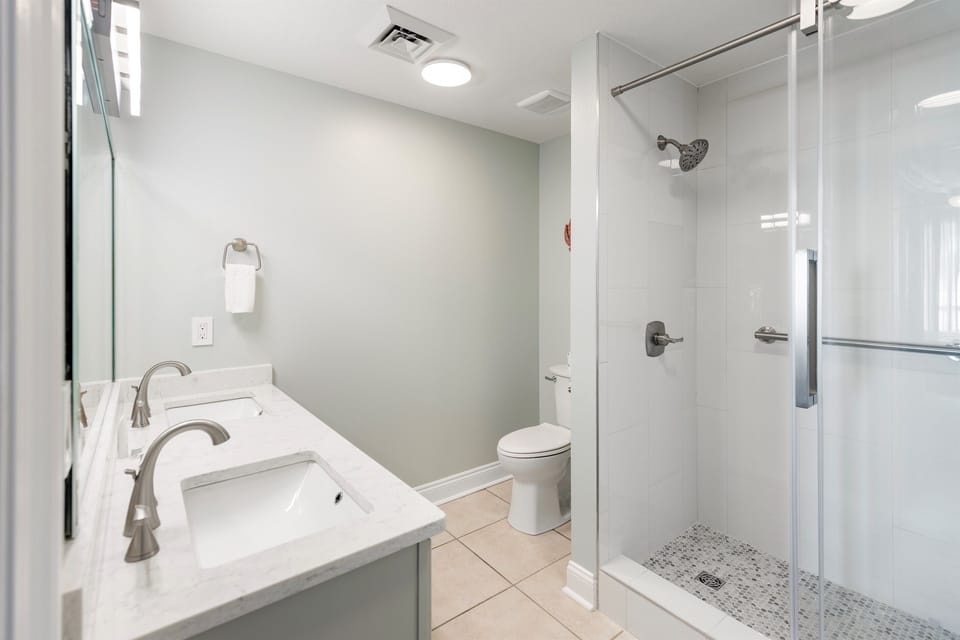 Unwind in your spa-like bathroom featuring a deep soaking tub and spacious glass-enclosed shower for ultimate relaxation.