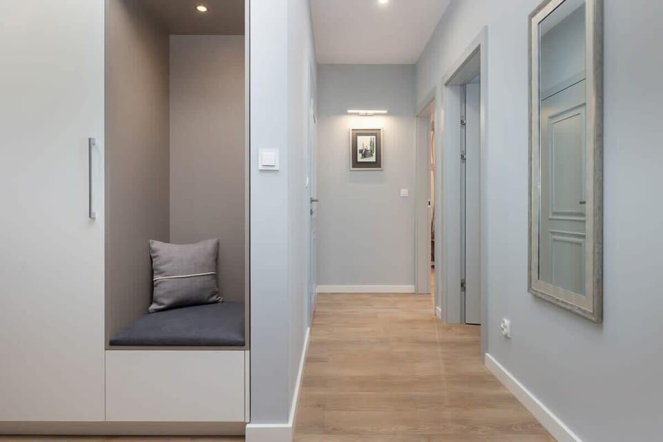 A bright hallway leading to other parts of the apartment, with framed artwork.