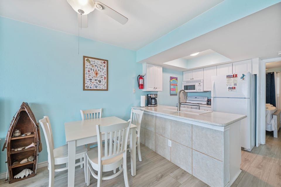 Prepare delicious meals in your fully equipped kitchen featuring granite counters, white cabinets, and a cozy dining nook perfect for morning coffee together.