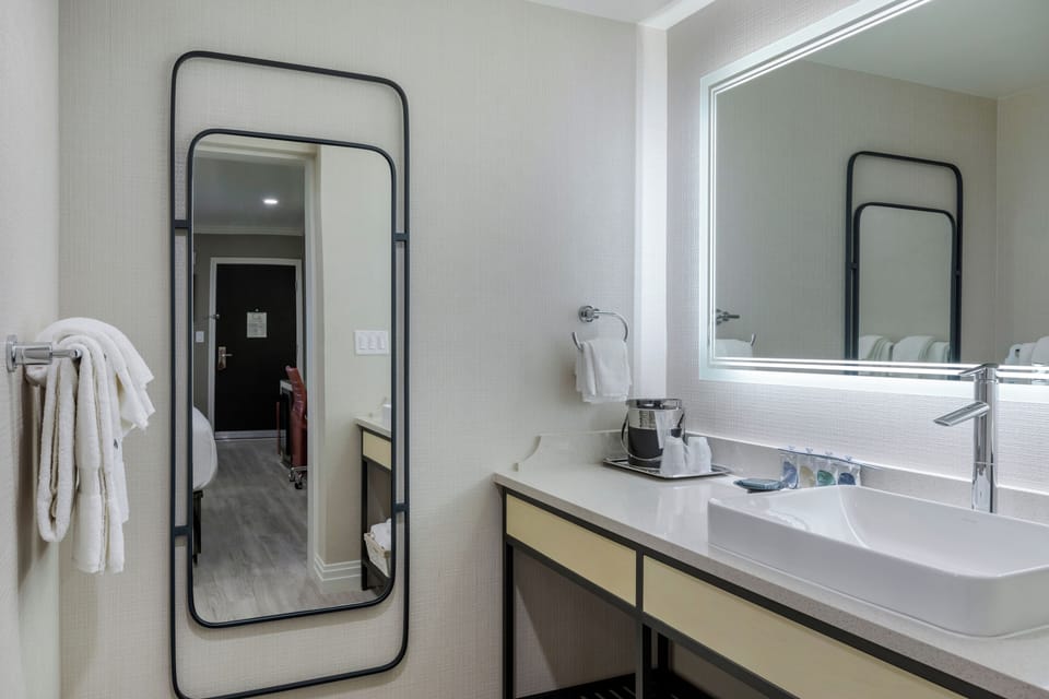 Freshen up at a bright vanity with plush towels and mirror.