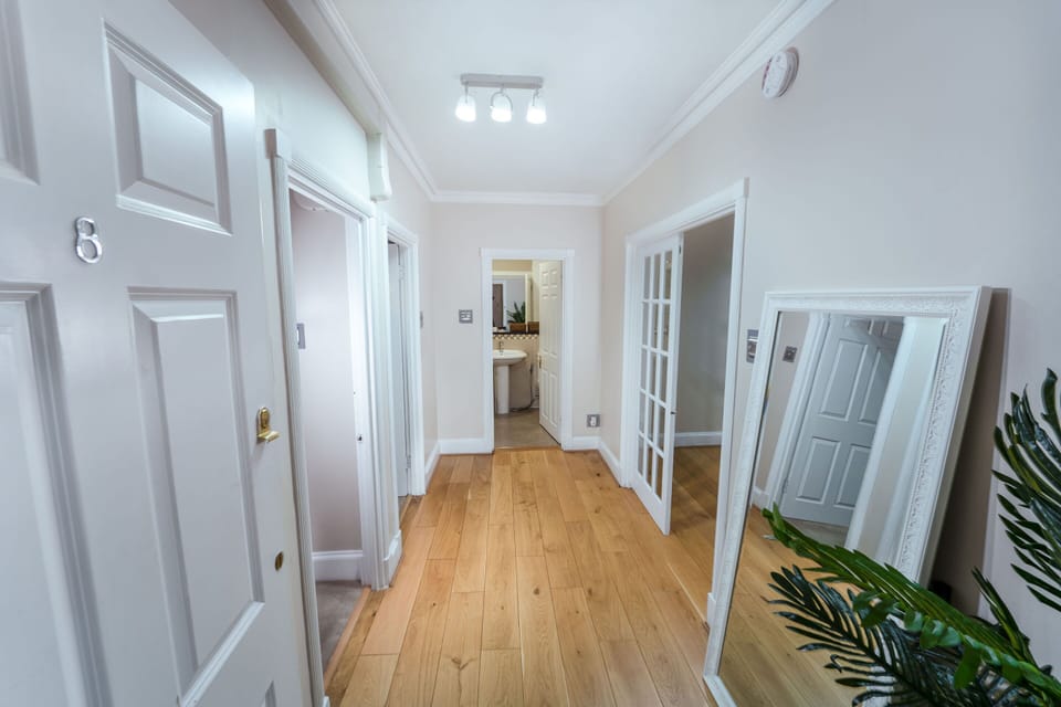 Bright hallway with wooden flooring and mirrored doors