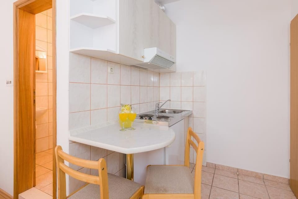 Kitchen of Podstrana luxury pool villa with chairs and sink for vacation and rent with friends and family
