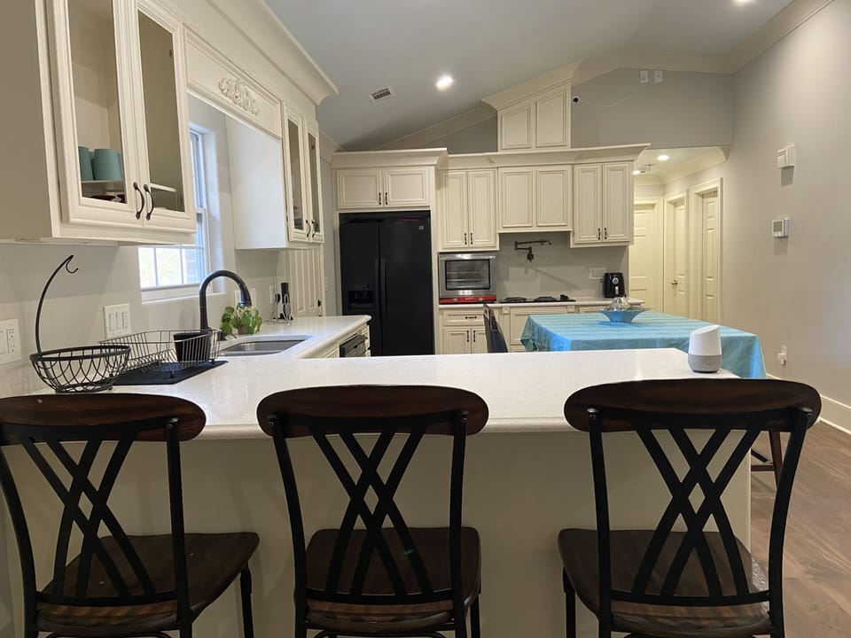 Modern kitchen with vaulted ceiling, led lights, white cabinets and counter tops