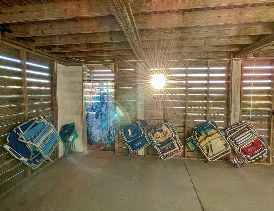 Covered storage area for beach chairs/supplies and outdoor shower