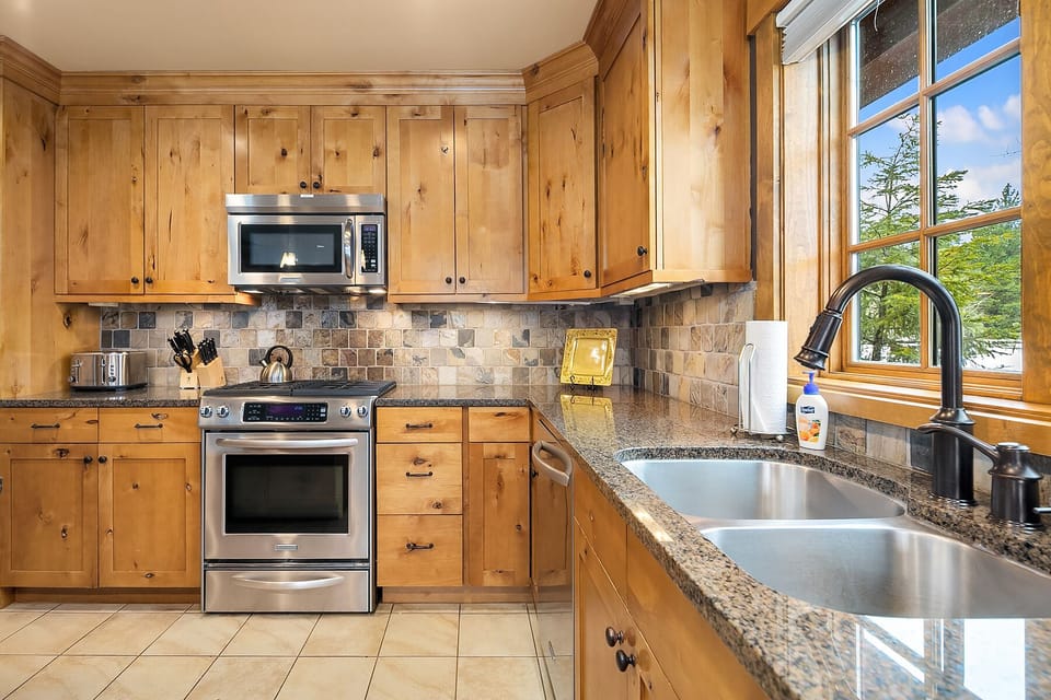 Trailhead Escape: - The luxurious kitchen features granite counters, stainless appliances, and a gas cooktop.