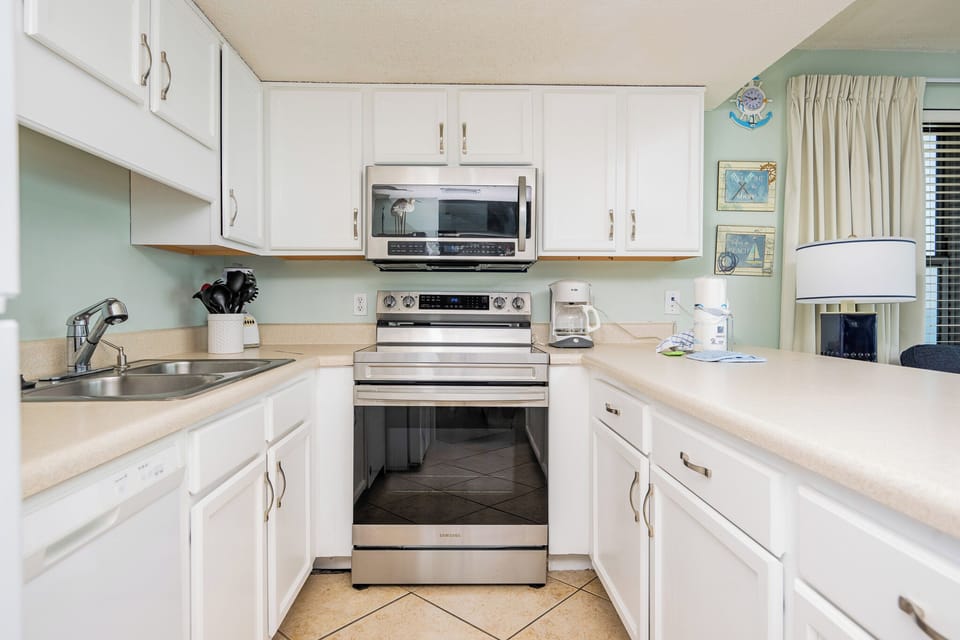 Kitchen featuring stainless appliances, ample counter space, and charming coastal decor accents