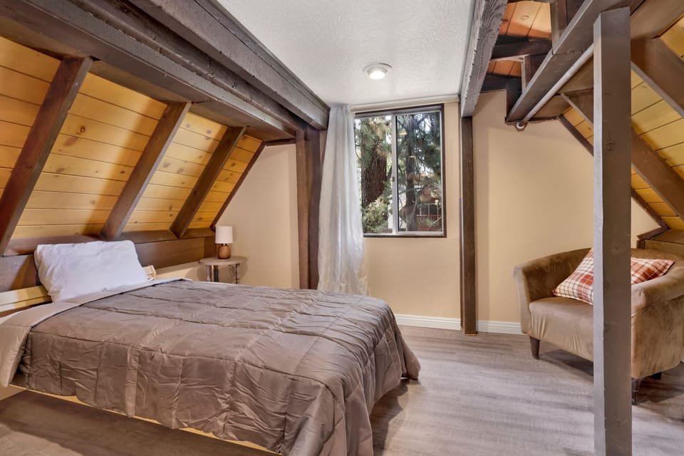 Peaceful cabin bedroom with plush bedding, and beautiful views—ideal for restful nights, cozy mornings, and a relaxing mountain escape.
