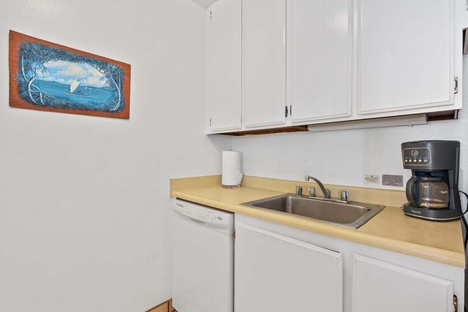 Tastefully updated kitchen with modern appliances, cookware, and a fresh island-inspired design — perfect for preparing quick meals or full dinners.