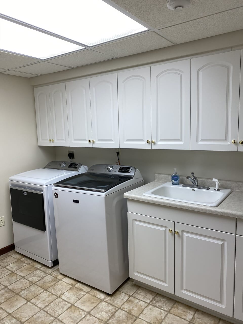 2nd laundry room located in lower level.  Maytag commercial equipment with sink.