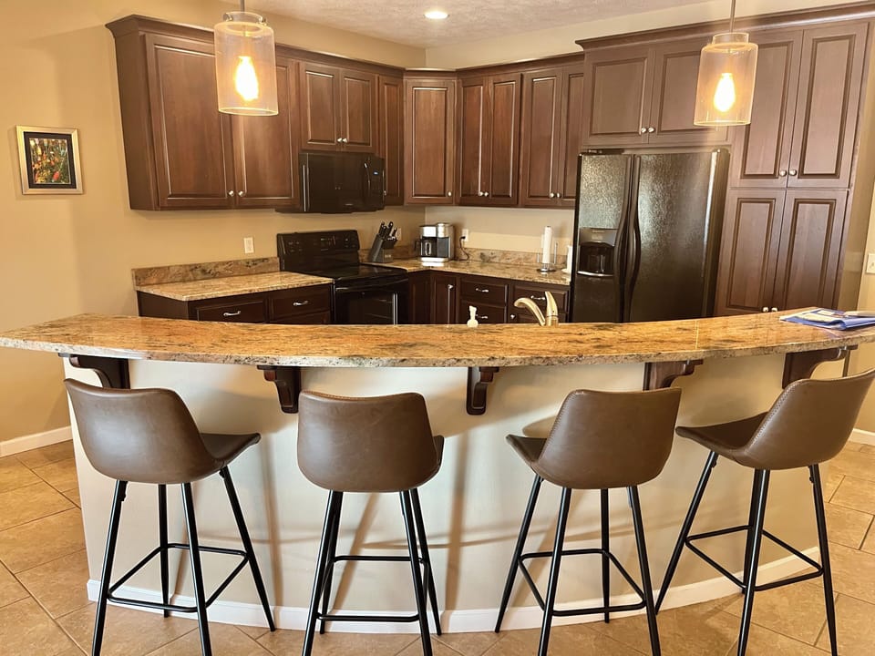 Fully stocked kitchen with granite countertops and bar seating for four people