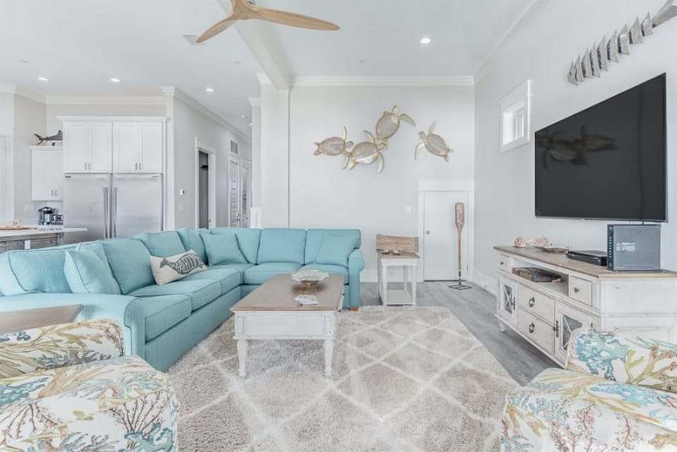 Sink into the plush turquoise sectional and unwind in this coastal-chic living space, where sea turtle art and ocean breezes create your perfect beach retreat.