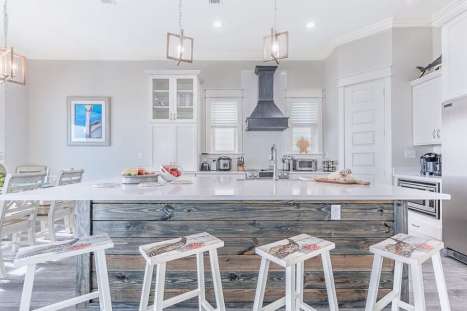 Your gourmet kitchen awaits with marble countertops, premium appliances, and coastal charm - perfect for preparing memorable meals together.