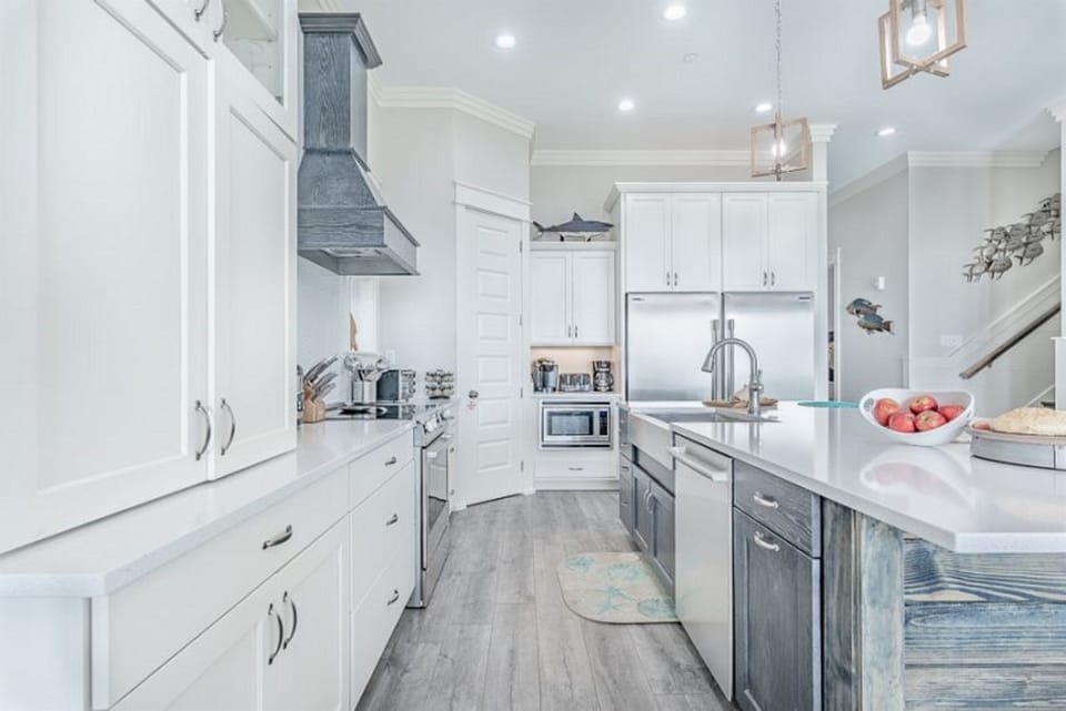 You'll love cooking in this stunning coastal kitchen with gleaming counters, modern appliances, and charming nautical touches throughout.