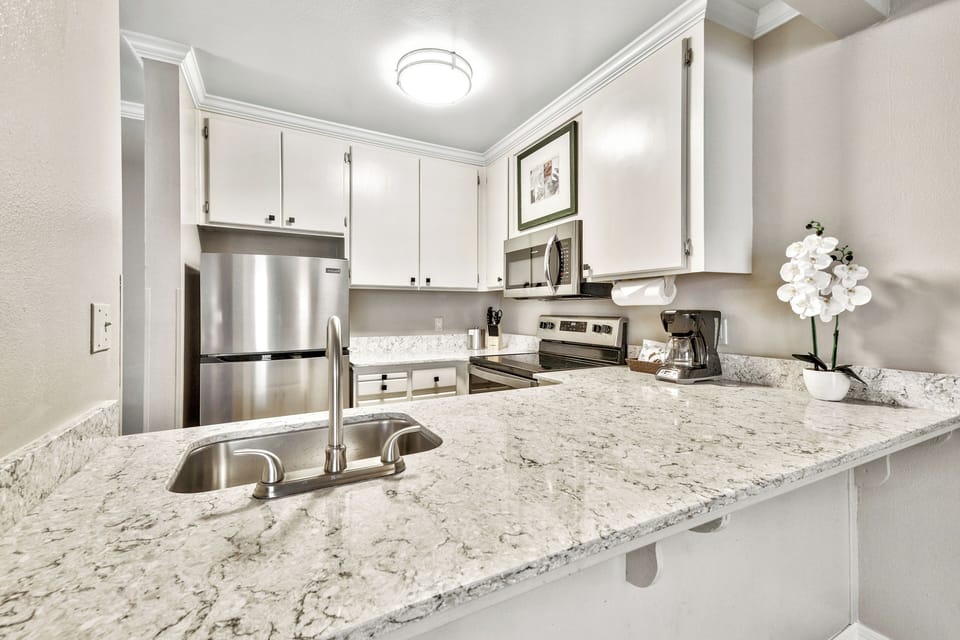 Cook with ease on granite counters in a gleaming kitchen.