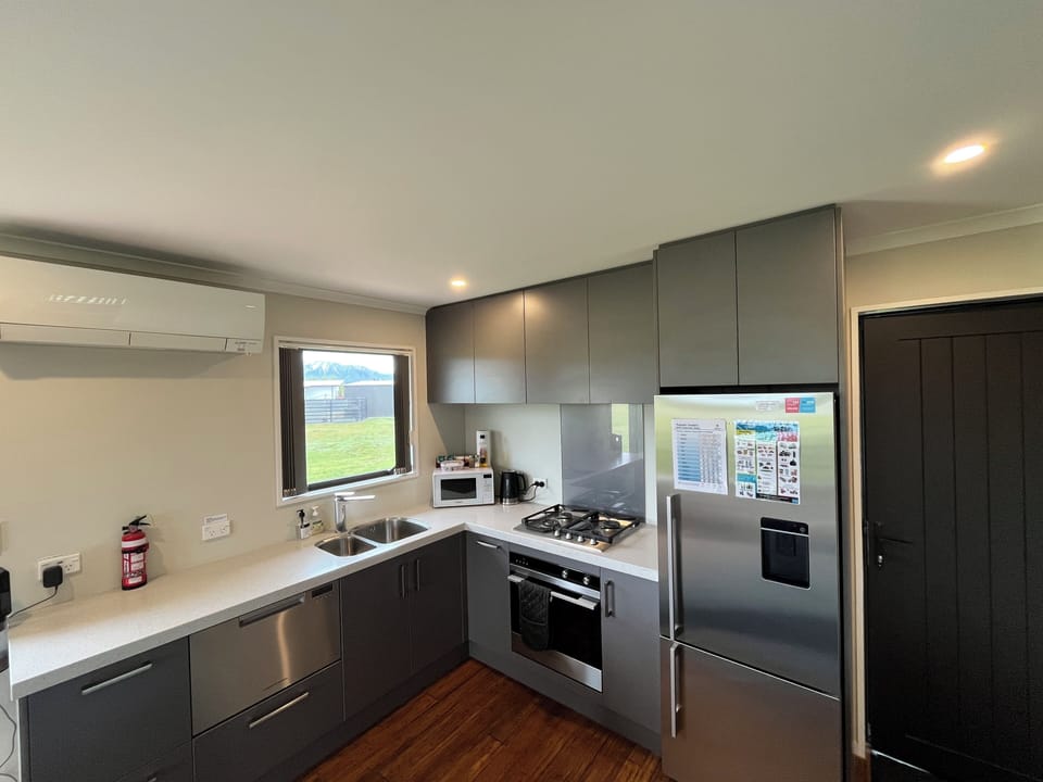 Kitchen with large fridge/freezer, microwave, dishwasher, oven & gas cooktop.
