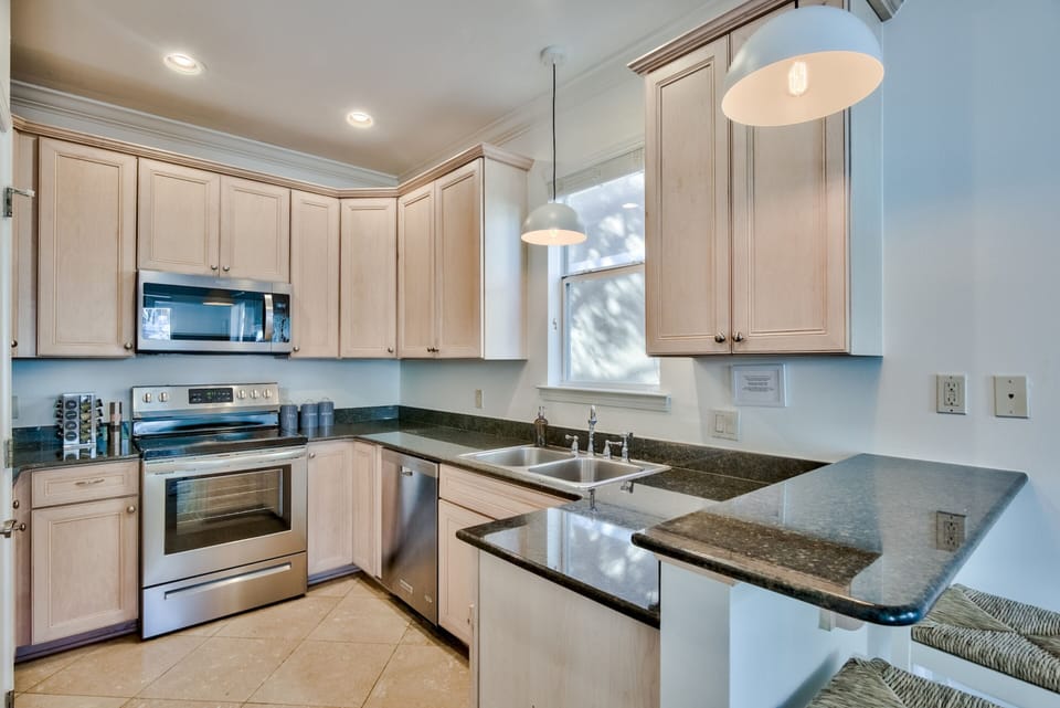 Kitchen includes modern appliances and a breakfast bar.
