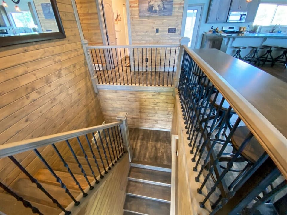 Warm wood staircase with handcrafted railings creates a welcoming, rustic centerpiece connecting beautiful living spaces.