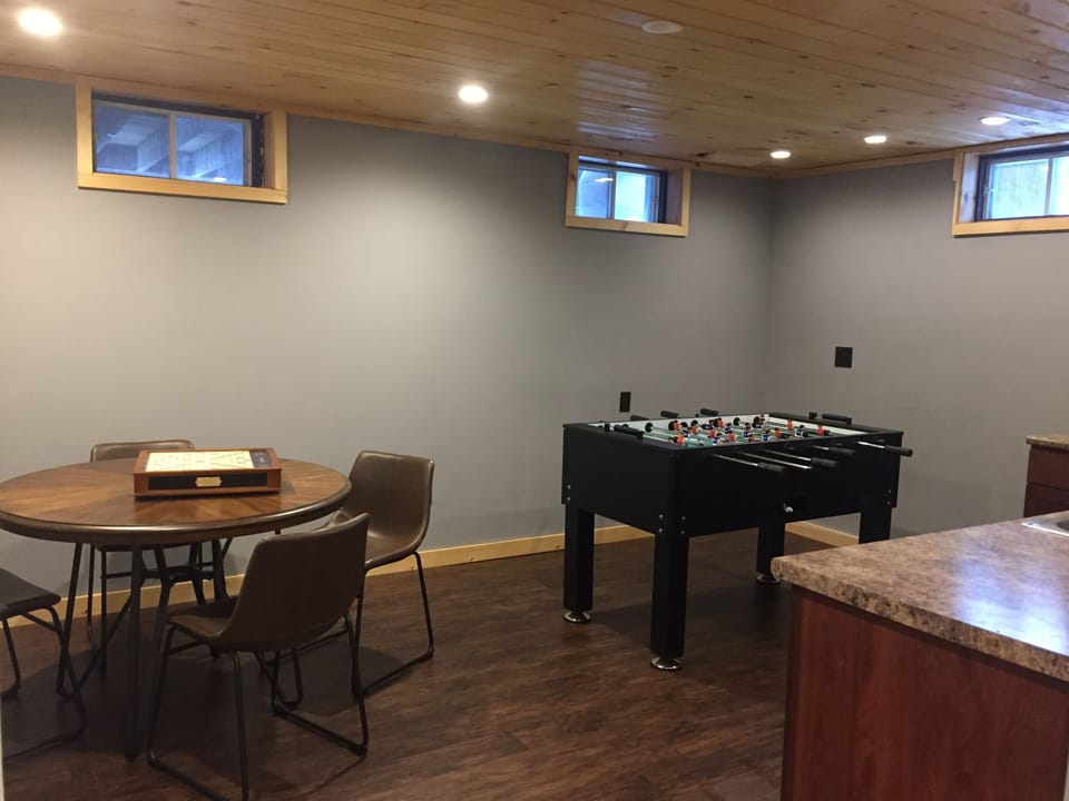 Game table and Foosball table in the basement with a TV in the room as well.