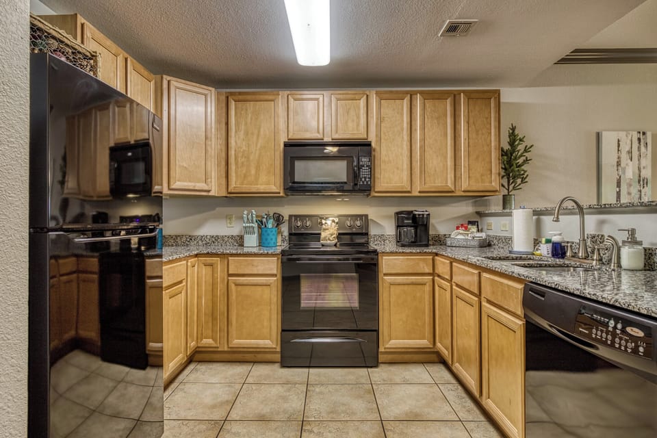 Fully stocked kitchen with granite counter tops & modern appliances for cooking
