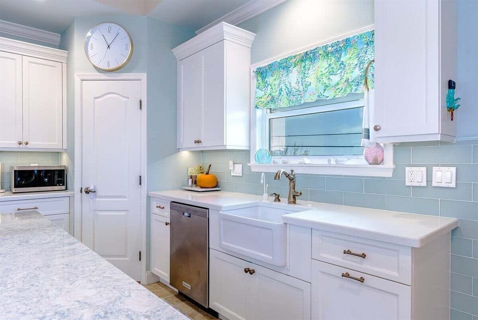 White cabinetry, abundant workspace, and modern appliances make preparing meals a pleasure.