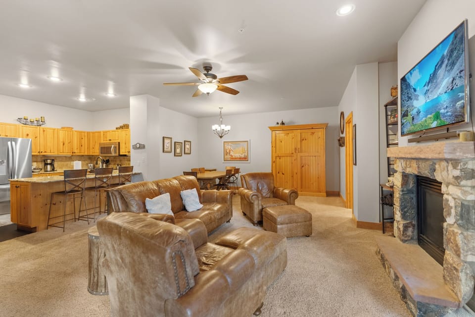 Unwind in your spacious living room with plush leather seating, warm fireplace, and open kitchen—perfect for memorable evenings together.