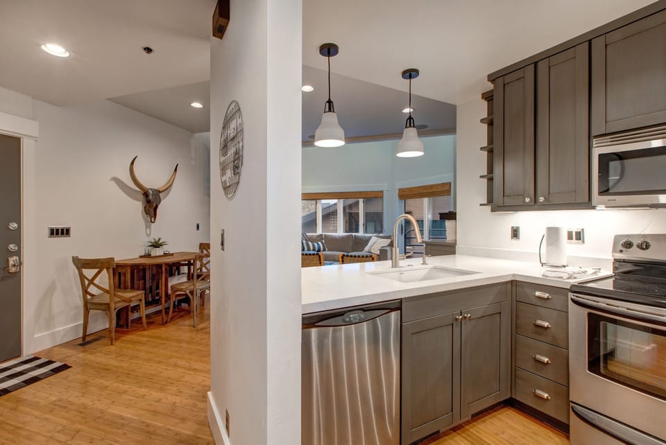 Fully Equipped Kitchen with gorgeous stone countertops, stainless steel kenmore appliances, and bar seating for four