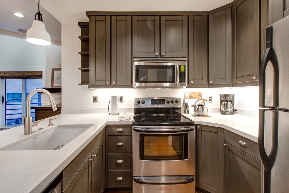 Fully Equipped Kitchen with gorgeous stone countertops, stainless steel kenmore appliances, and bar seating for four