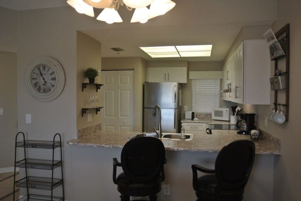 Well-equipped kitchen with modern appliances and breakfast bar seating.