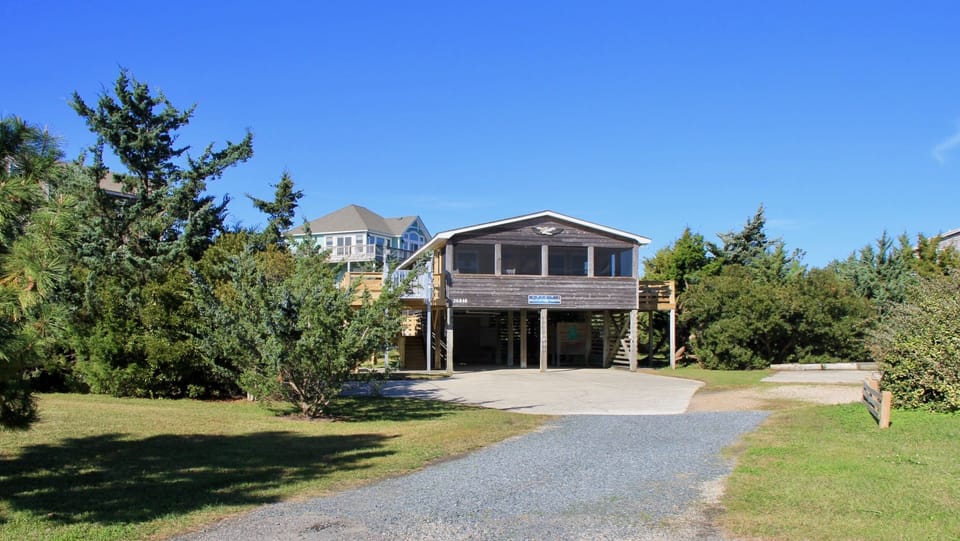 The beach house is set back from Colony Drive by a long gravel driveway