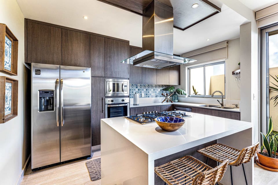 The kitchen is fully-loaded with high-end appliances including a gas stove, oven, full-sized refrigerator, tea kettle, coffee maker, & toaster.