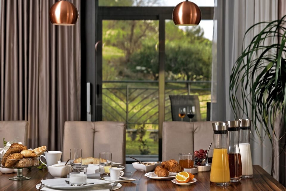 Breakfast served on the wooden dining table on the ground floor of the luxury villa Happiness and exit to the courtyard of the villa