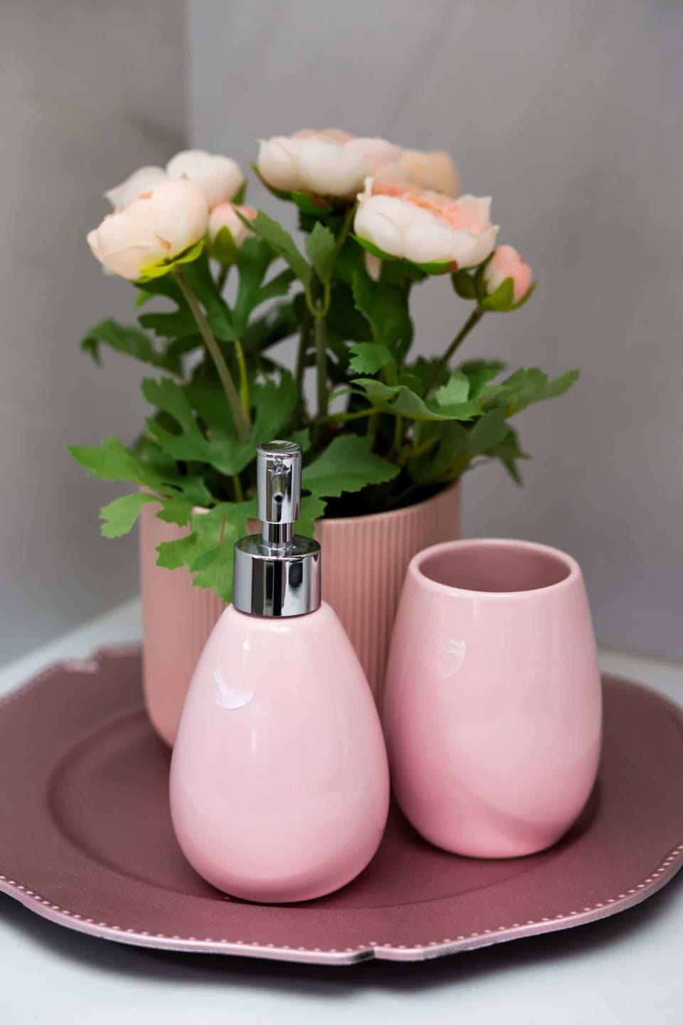 A tray with pink vases and flowers, adding a soft decorative touch.