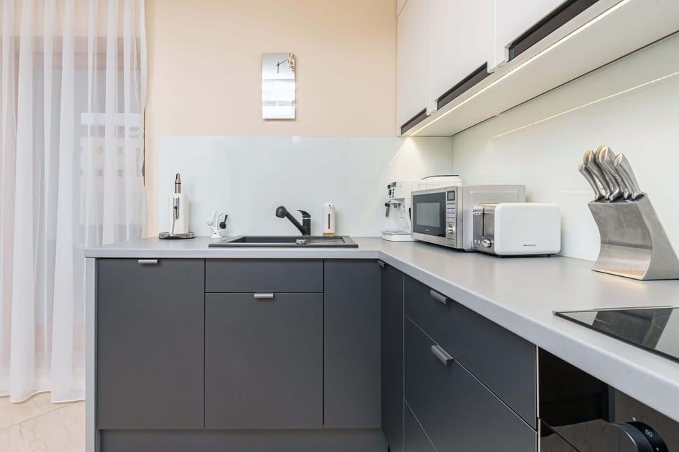 A well-organized kitchen, featuring ample workspace, a range hood, and a sleek design.