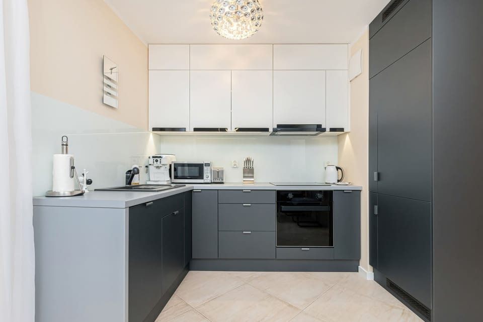 A fully equipped kitchen with dark cabinets, light countertops, and modern appliances.