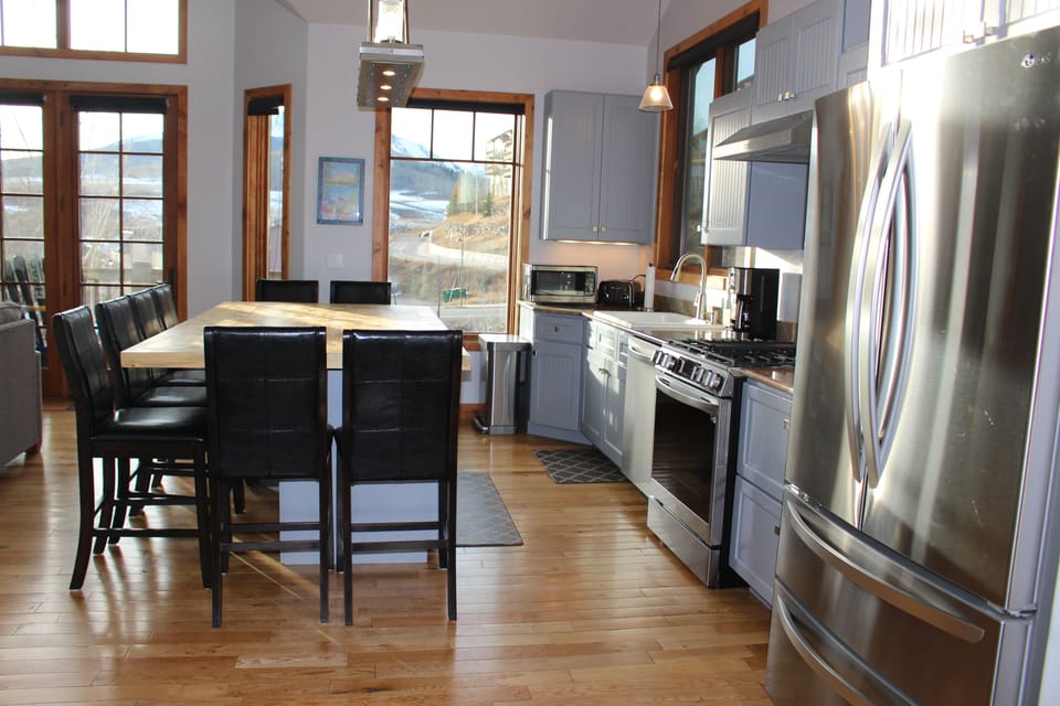 Gourmet kitchen with large island/table and new stainless steel appliances